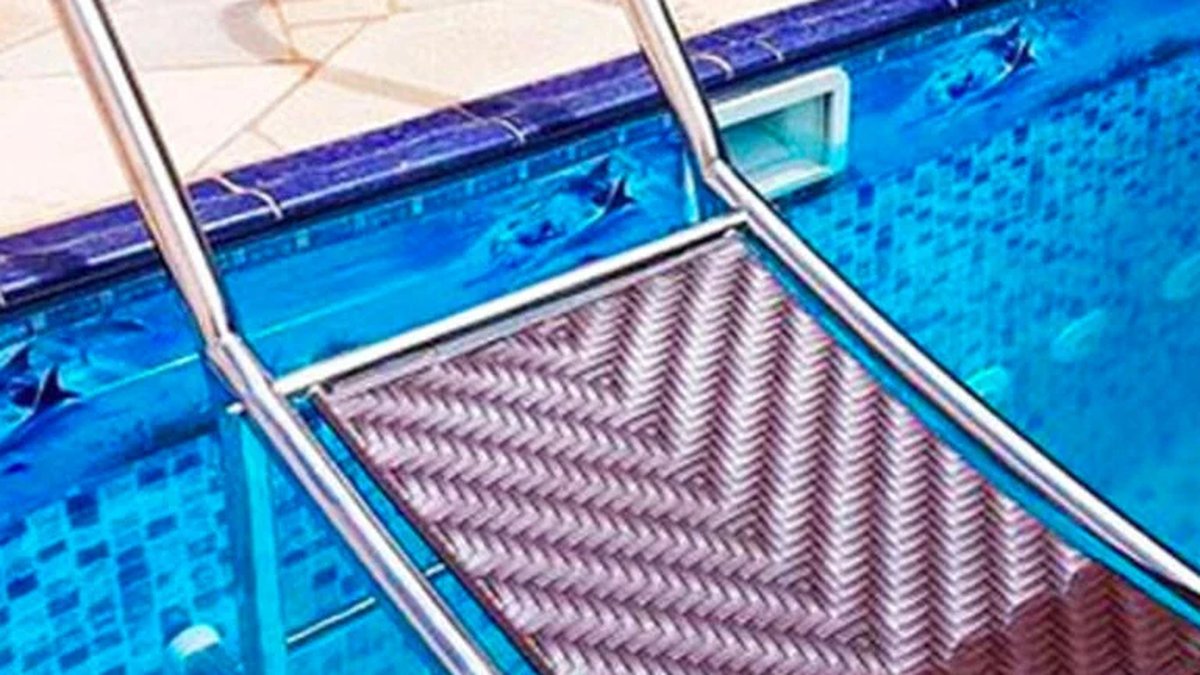 Escada de acesso em aço inox instalada na borda de uma piscina revestida
